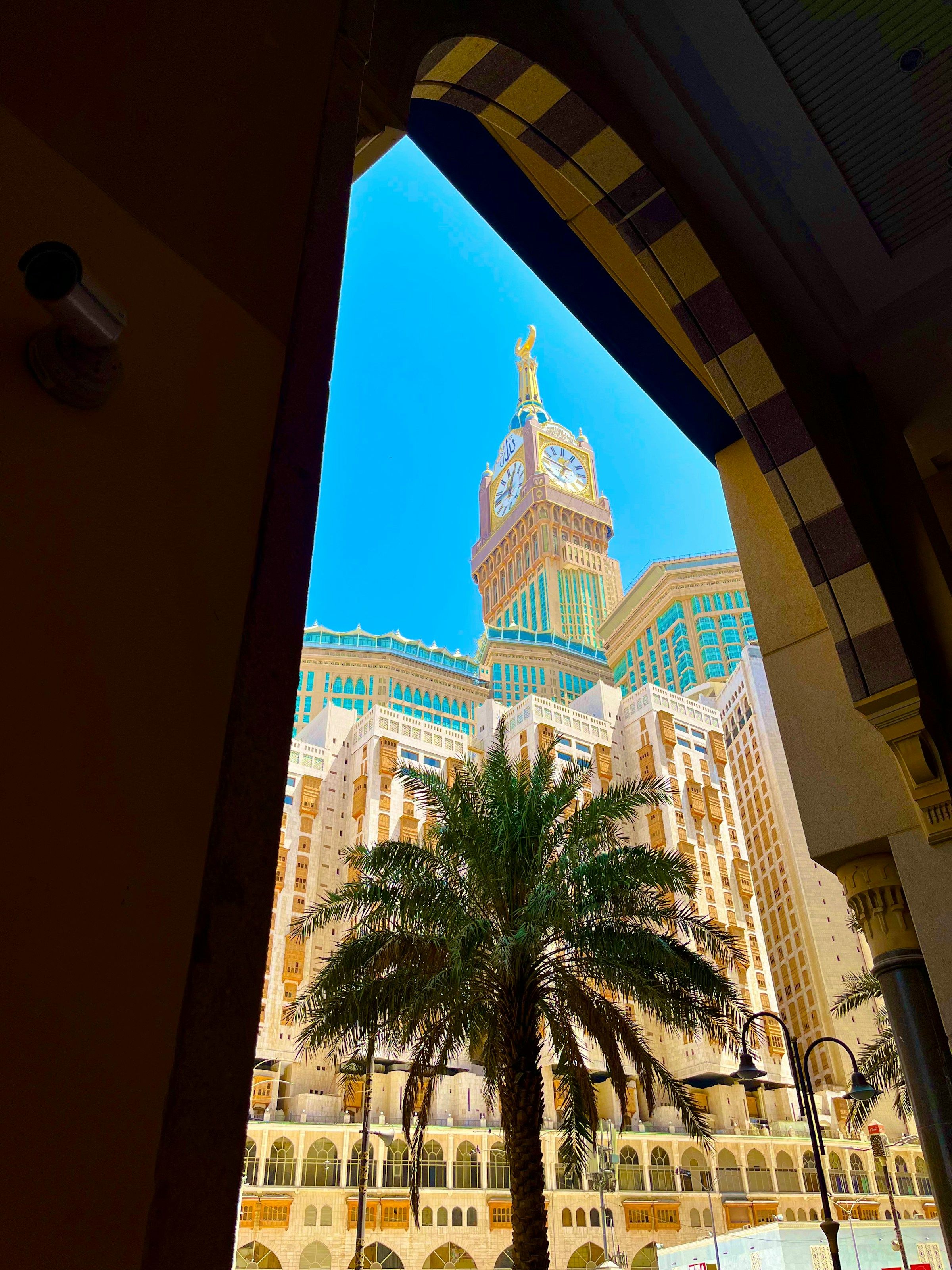 The Abraj Al Bait hotel towers and Makkah Royal Clock Tower framed by an arch of Masjid al-Haram