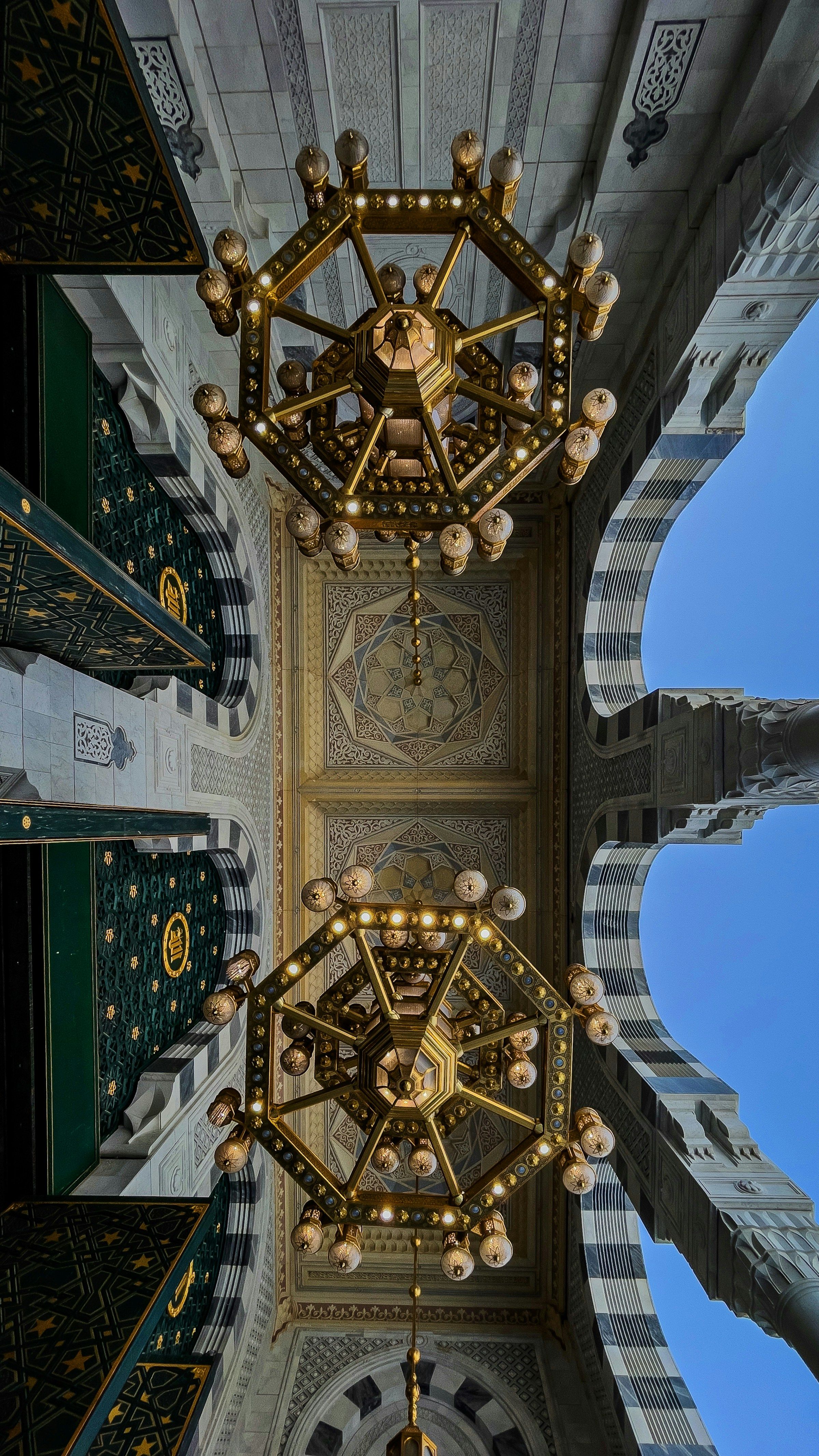 Chandeliers and decorated arches in a colonnade of Masjid al-Haram