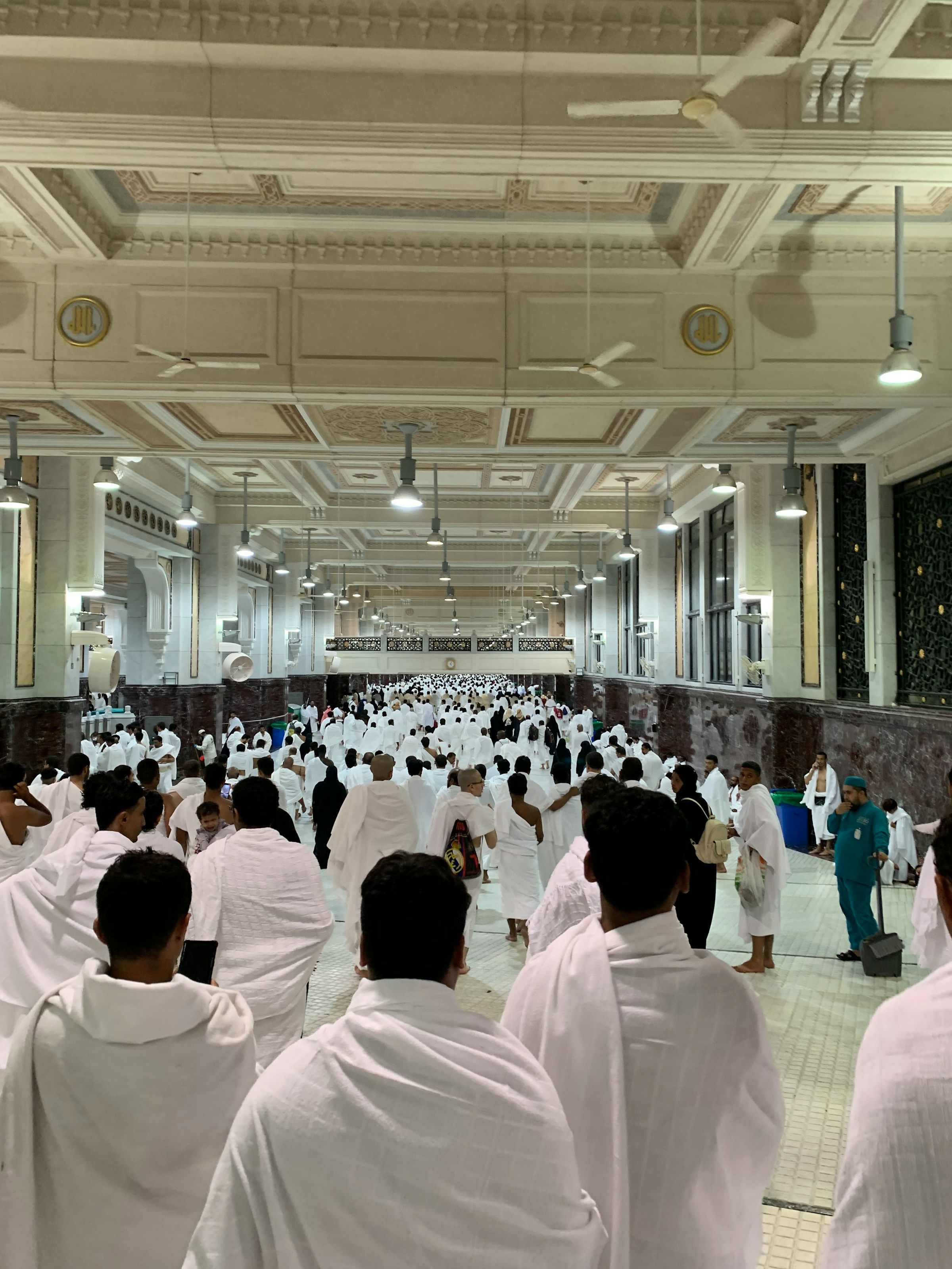 Pilgrims in ihram walking through the Safa and Marwa gallery in Masjid al-Haram